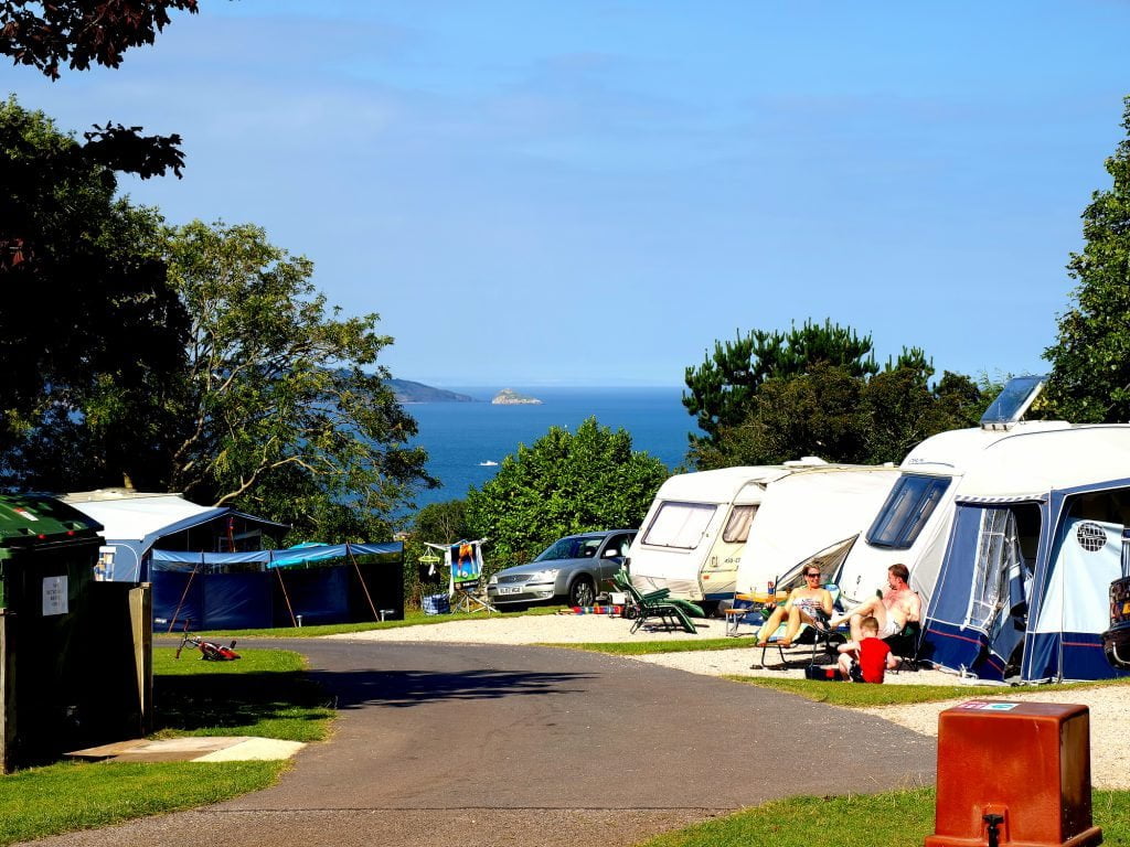 Camping in Devon, Verenigd Koninkrijk. Vakantiegangers kamperen met uitzicht over het water.